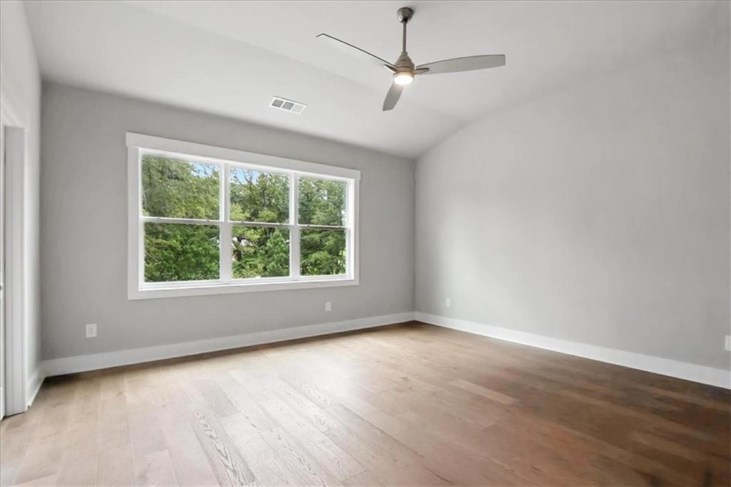 95 Old Town Road Dacula, GA 30019 - Photo 40 of 74 an empty room with wooden floor fan and windows