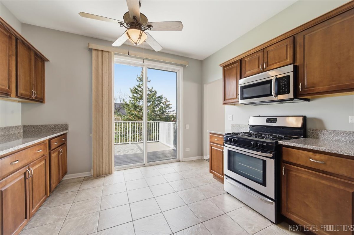 1102 Delta Drive, Unit 1102 Elgin, IL 60123 - Photo 12 of 29 a kitchen with stainless steel appliances granite countertop a stove and a microwave