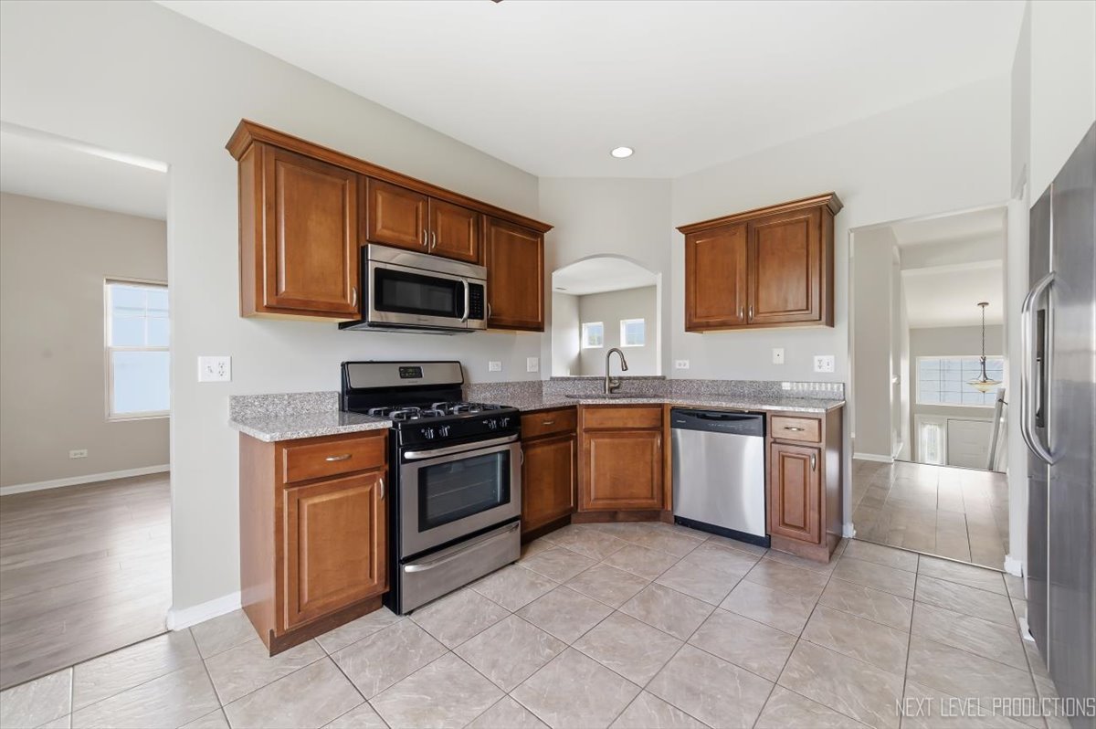 1102 Delta Drive, Unit 1102 Elgin, IL 60123 - Photo 14 of 29 a kitchen with granite countertop a stove top oven microwave and cabinets