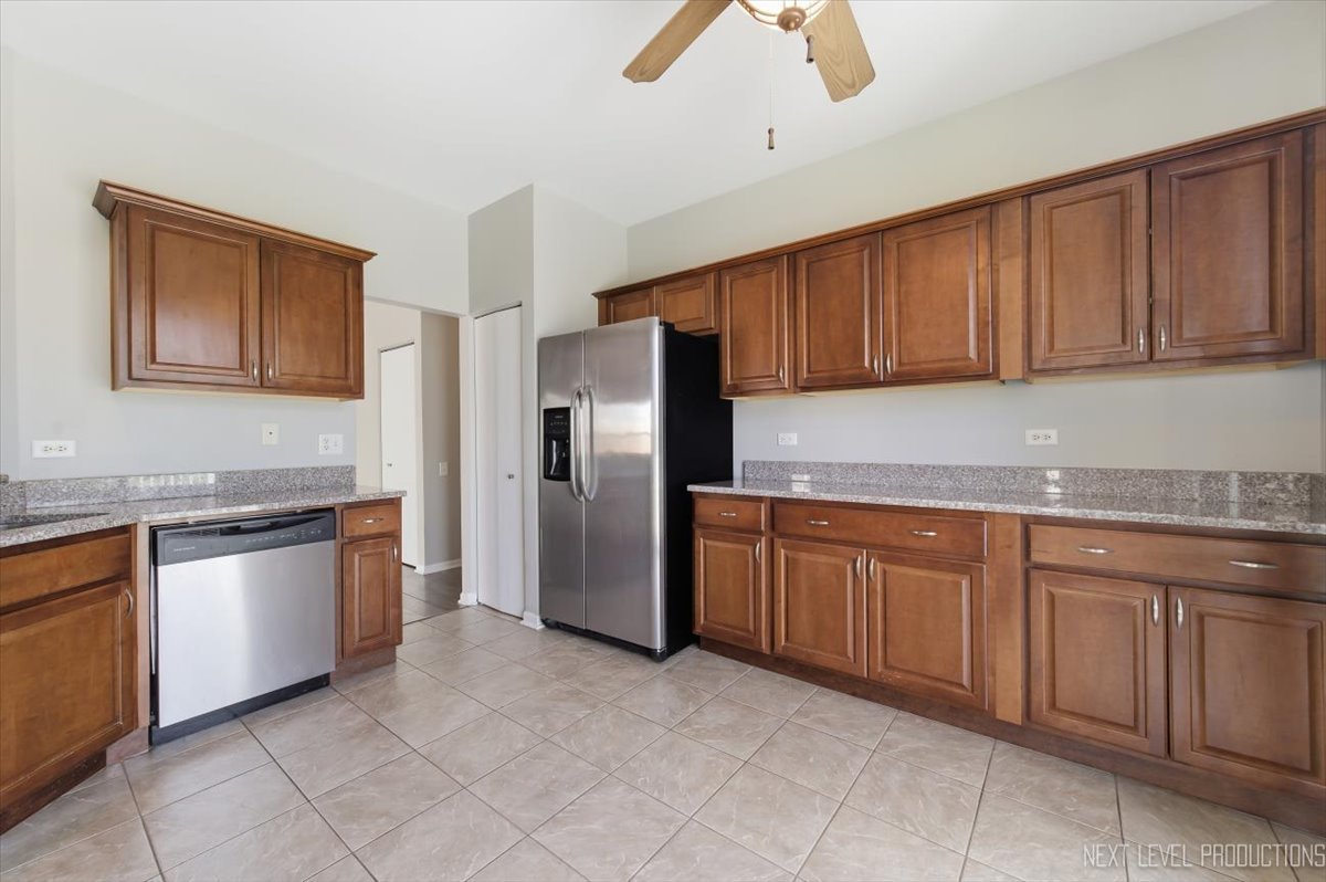 1102 Delta Drive, Unit 1102 Elgin, IL 60123 - Photo 15 of 29 a kitchen with granite countertop stainless steel appliances and wooden cabinets