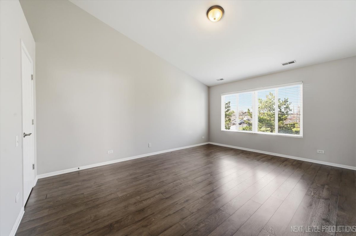 1102 Delta Drive, Unit 1102 Elgin, IL 60123 - Photo 17 of 29 an empty room with wooden floor and windows