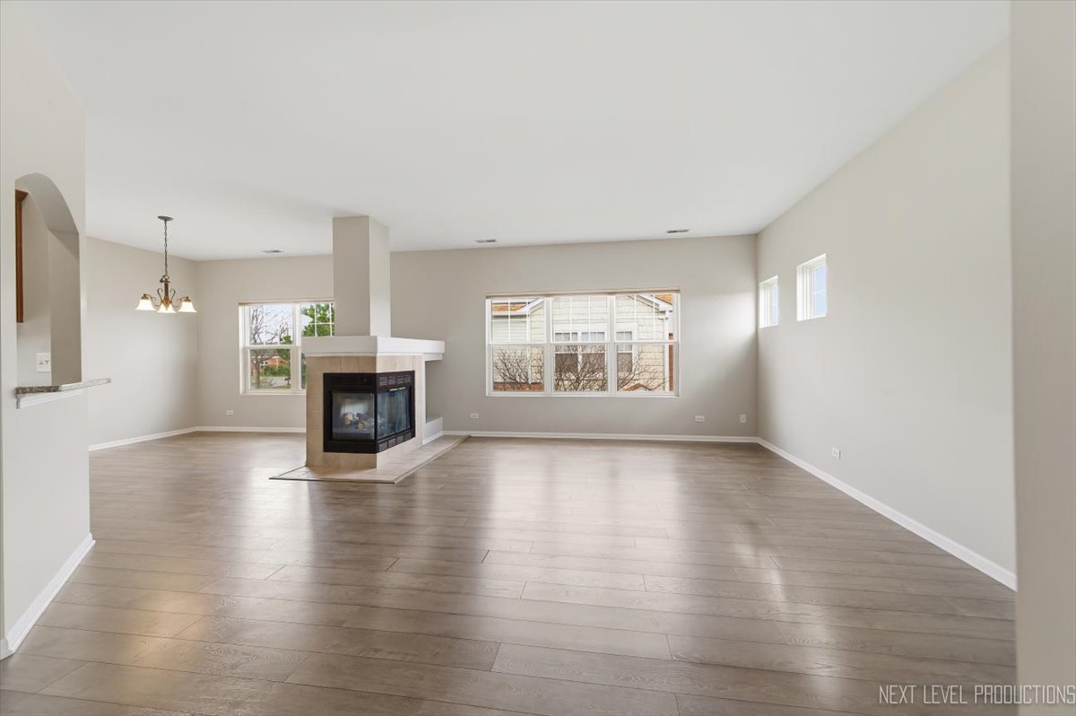 1102 Delta Drive, Unit 1102 Elgin, IL 60123 - Photo 5 of 29 an empty room with wooden floor fireplace and windows