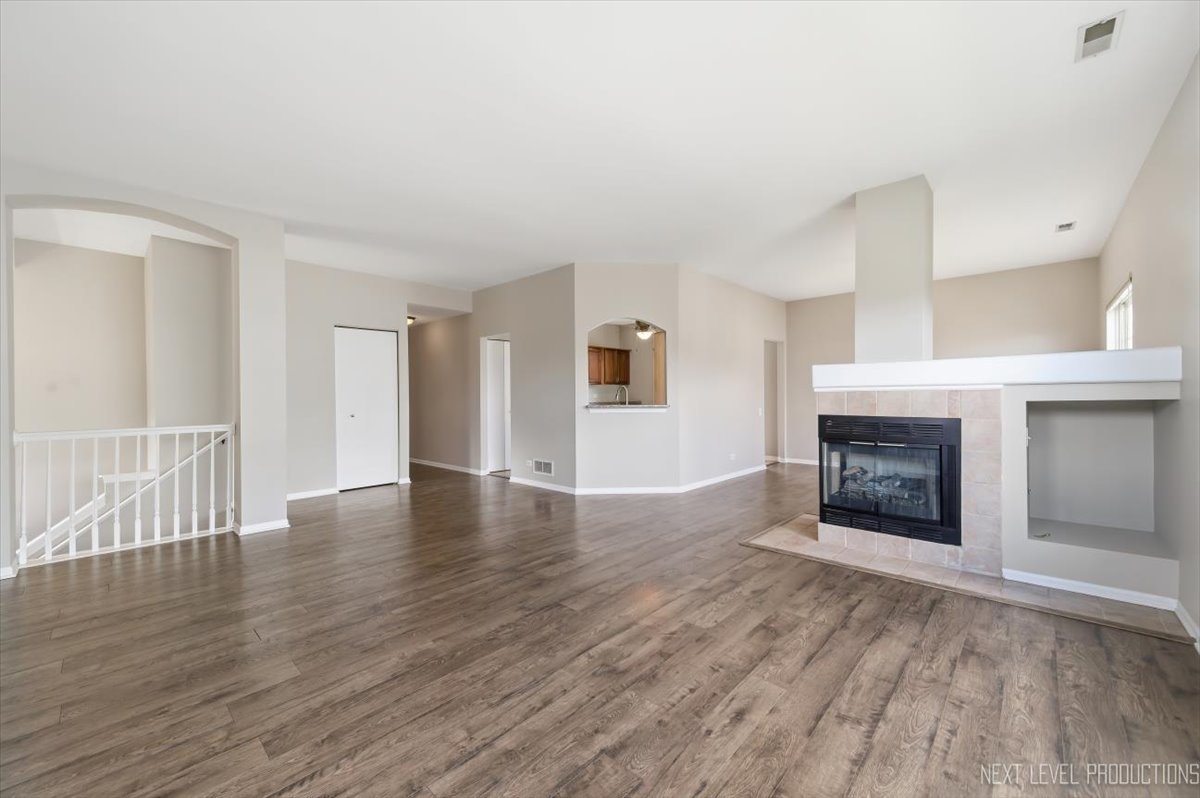 1102 Delta Drive, Unit 1102 Elgin, IL 60123 - Photo 7 of 29 an empty room with wooden floor and fireplace