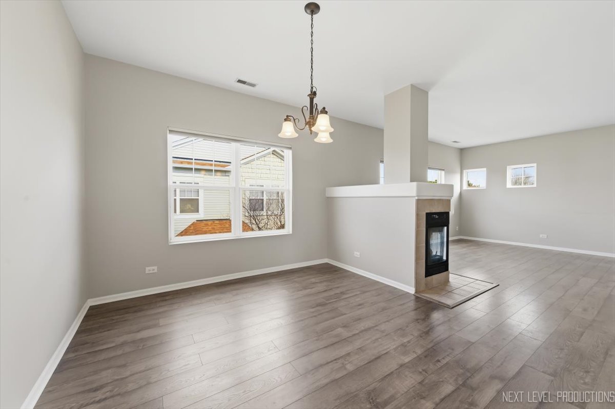 1102 Delta Drive, Unit 1102 Elgin, IL 60123 - Photo 8 of 29 a view of a room with wooden floor a ceiling fan and windows