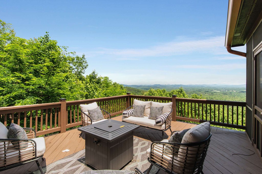 231 Sunrock Mountain Trail Blue Ridge, GA 30513 - Photo 25 of 61 a balcony with wooden floor table and chairs
