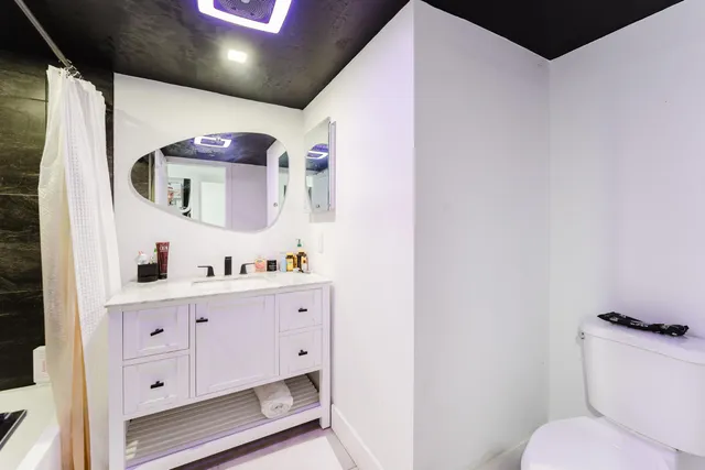 a bathroom with a toilet sink and mirror