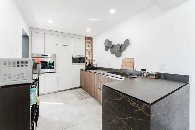 a kitchen with a sink dishwasher a stove and a refrigerator with wooden floor