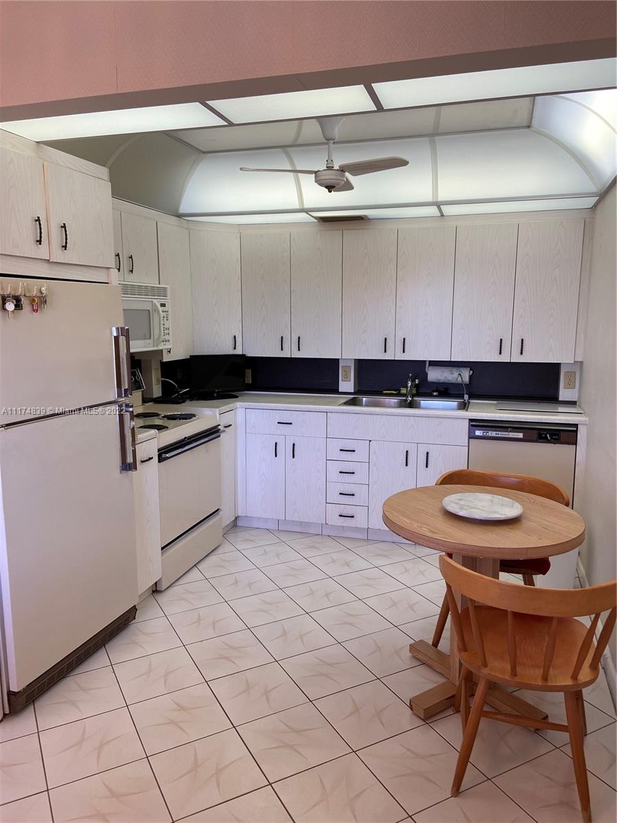 4034 Rexford B, Unit 4034 Boca Raton, FL 33434 - Photo 1 of 15 a kitchen with stainless steel appliances granite countertop a sink and cabinets