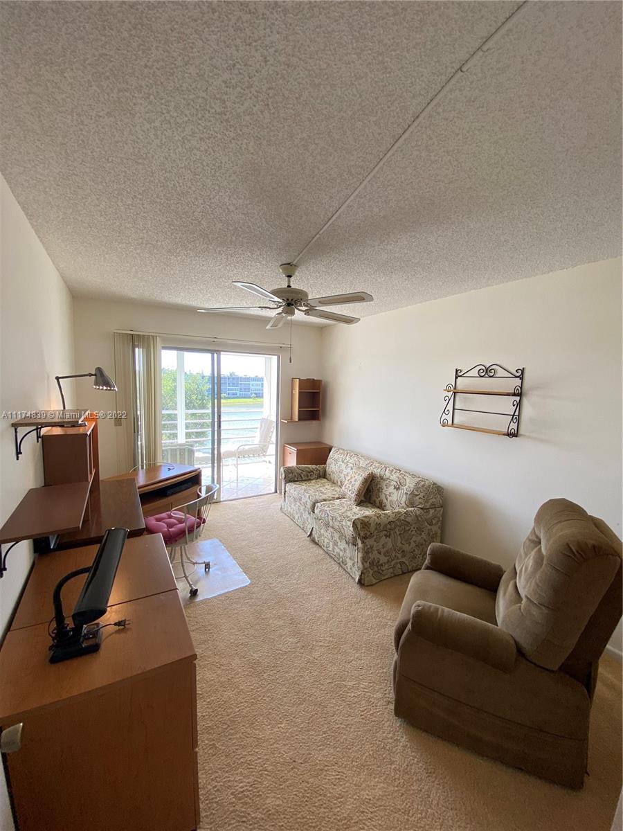 4034 Rexford B, Unit 4034 Boca Raton, FL 33434 - Photo 12 of 15 a living room with furniture and a flat screen tv