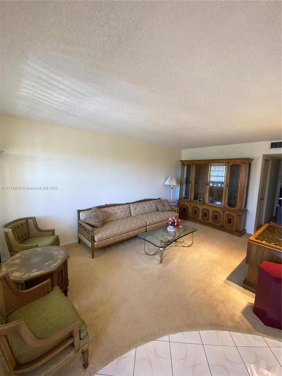 4034 Rexford B, Unit 4034 Boca Raton, FL 33434 - Photo 2 of 15 a living room with furniture a flat screen tv and rug