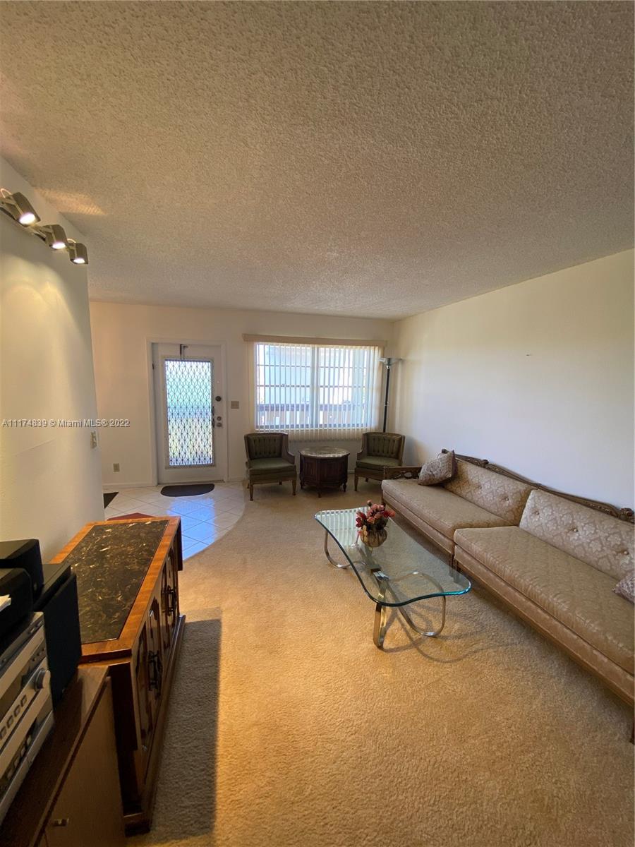 4034 Rexford B, Unit 4034 Boca Raton, FL 33434 - Photo 3 of 15 a living room with furniture and a flat screen tv