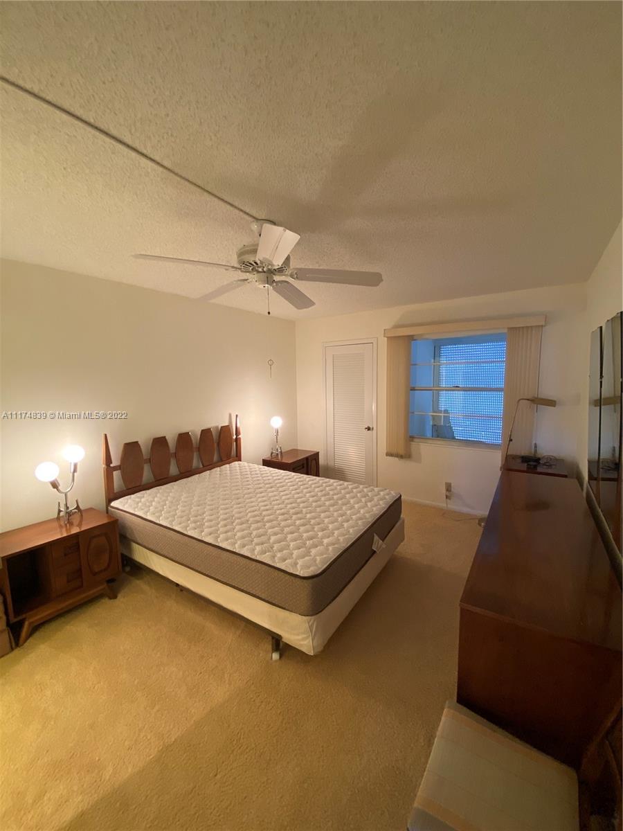 4034 Rexford B, Unit 4034 Boca Raton, FL 33434 - Photo 4 of 15 a bed room with a bed and a dresser