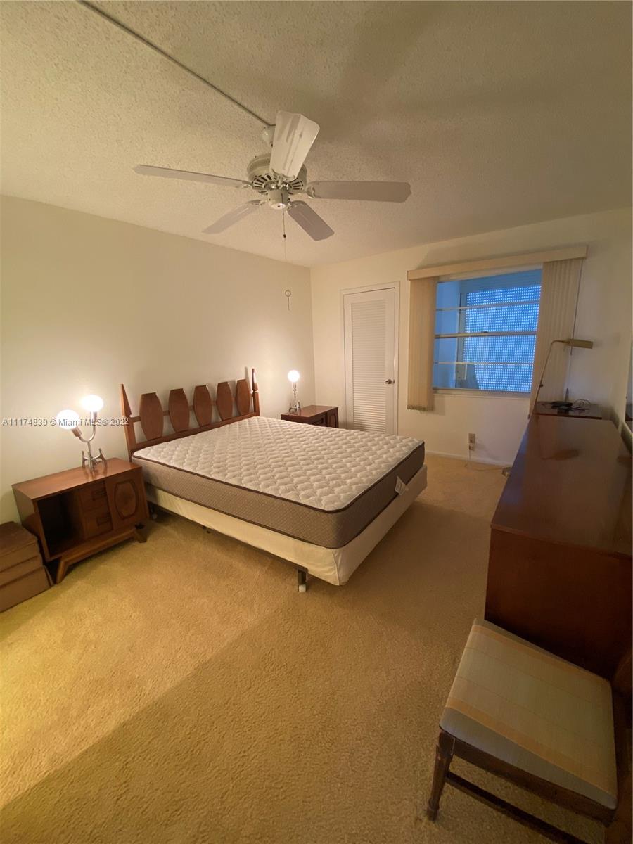 4034 Rexford B, Unit 4034 Boca Raton, FL 33434 - Photo 5 of 15 a bedroom with a bed and ceiling fan