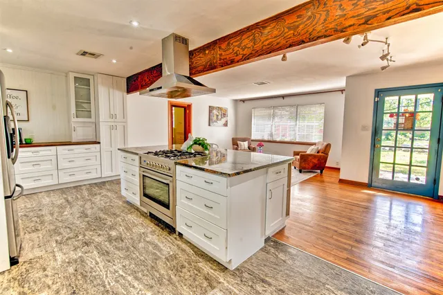 a kitchen with stainless steel appliances granite countertop a stove a sink and a refrigerator