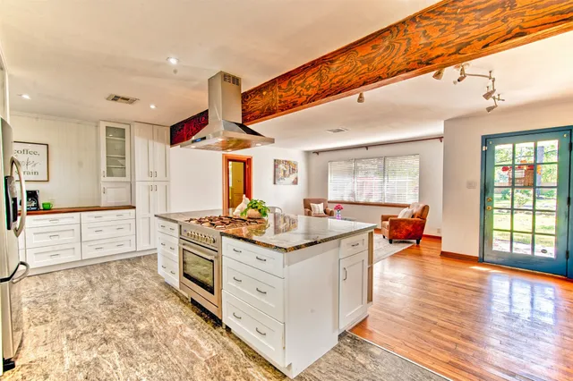 a kitchen with stainless steel appliances granite countertop a stove and a wooden floors