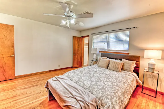 a bedroom with a bed and next to a window