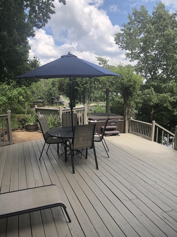 175 Holly Tree Drive Estill Springs, TN 37330 - Photo 3 of 38 a view of a roof deck with table and chairs under an umbrella with wooden floor