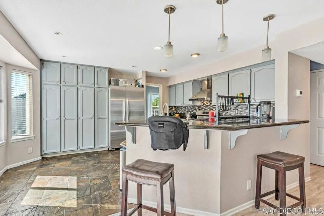 a kitchen with stainless steel appliances granite countertop a sink refrigerator and cabinets