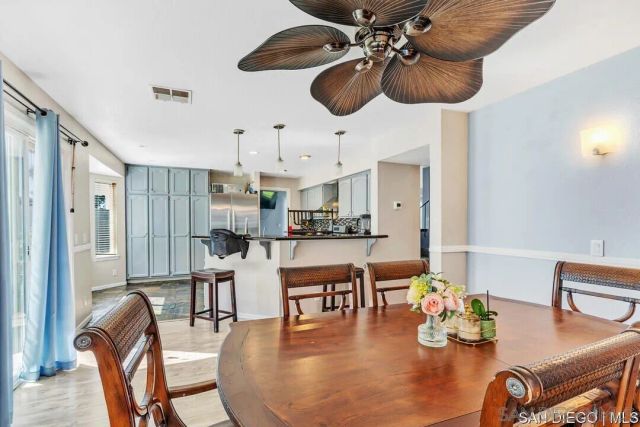 a dining room with wooden floor a chandelier a glass table and chairs
