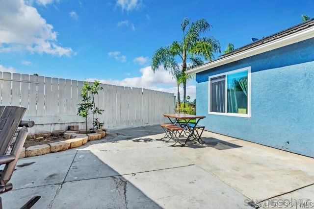 a view of a backyard with table and chairs and potted plants