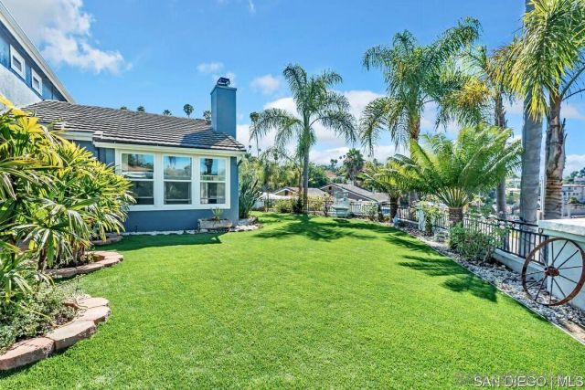 a view of a house with a yard and potted plants