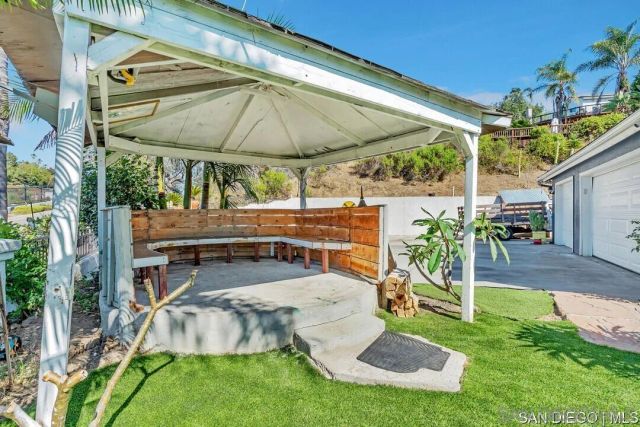 an outdoor sitting area with couch and umbrella