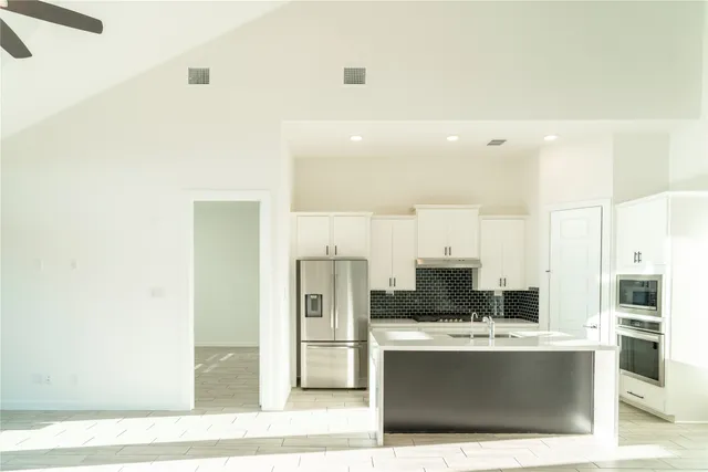 a view with kitchen island a sink a stove and a refrigerator