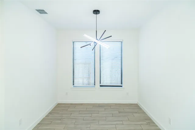 a view of a room with wooden floor and a ceiling fan