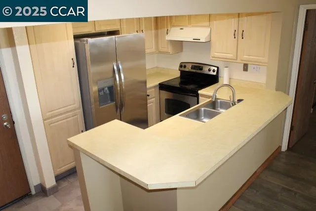 a kitchen with stainless steel appliances a refrigerator and a stove