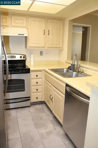 a kitchen with a stove sink and cabinets