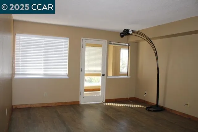 a view of a livingroom with wooden floor and a window