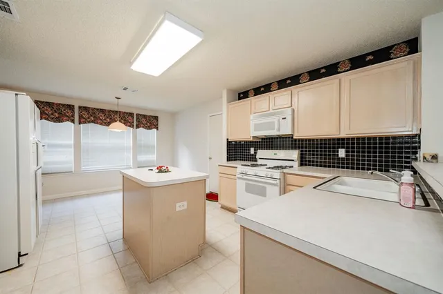 a kitchen with white cabinets and white appliances
