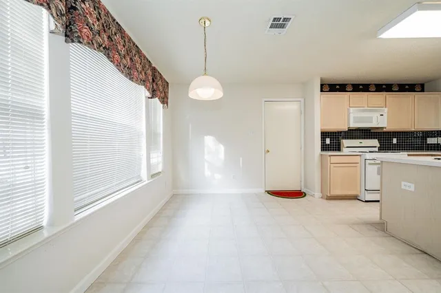 a kitchen filled with white cabinets and white appliances