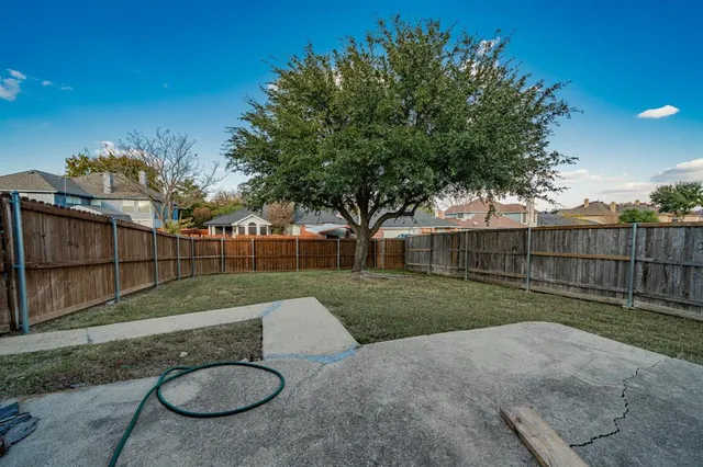 a view of a yard with a house and a large tree