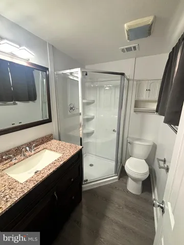 a bathroom with a granite countertop sink toilet and shower