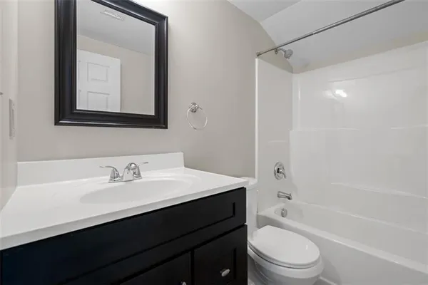 a bathroom with a toilet a sink a mirror a bathtub and vanity