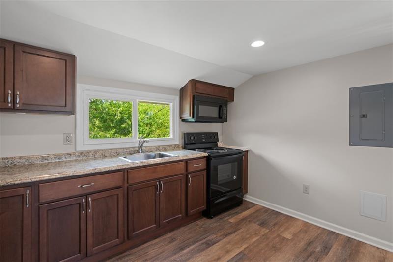 1122 Pittsburgh Road Valencia, PA 16059 - Photo 15 of 25 a kitchen with granite countertop a stove a sink and a microwave
