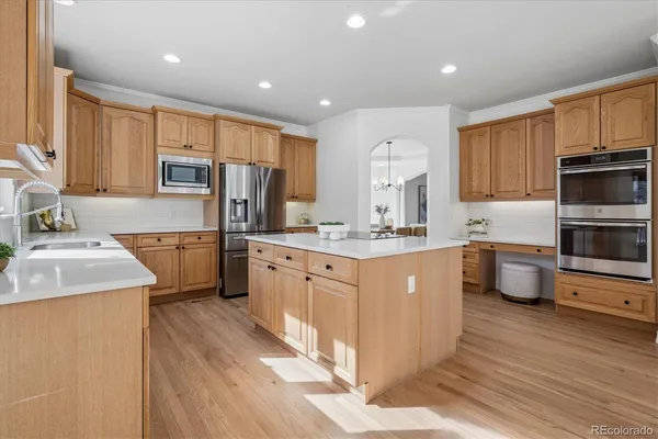 a kitchen with a sink wooden cabinets and stainless steel appliances