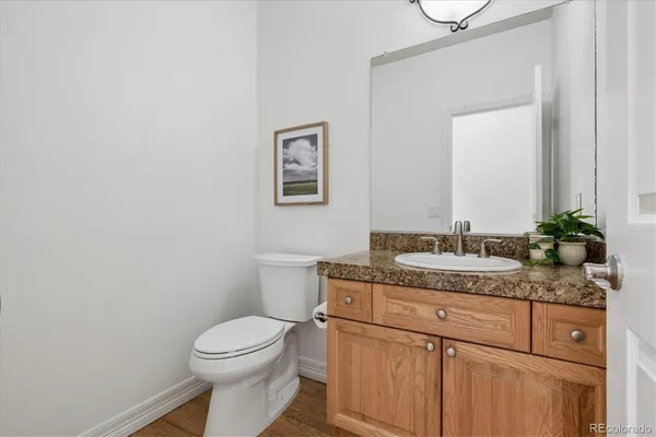 a bathroom with a granite countertop toilet sink and mirror