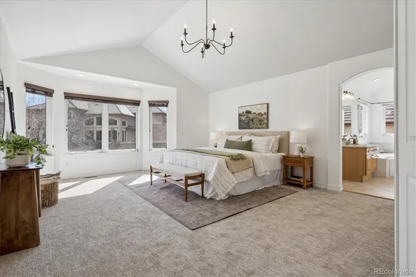 a spacious bedroom with a bed couch and window
