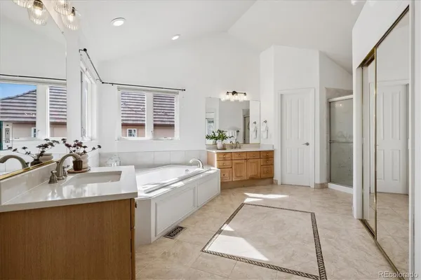 a bathroom with a tub sink shower and mirror
