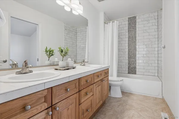 a bathroom with a double vanity sink toilet and shower