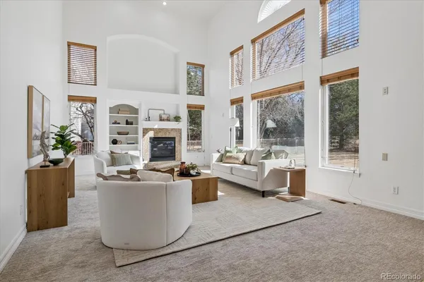 a living room with furniture a large window and a fireplace