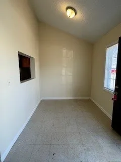 an empty room with a flat screen tv and a window