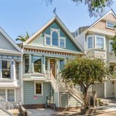 a front view of a house with a tree