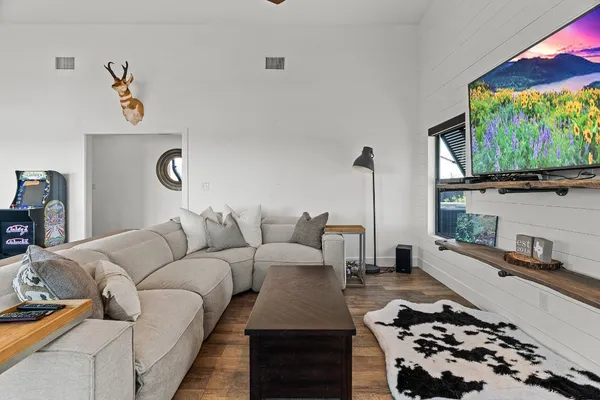 a view of a dining room and livingroom with furniture wooden floor a chandelier