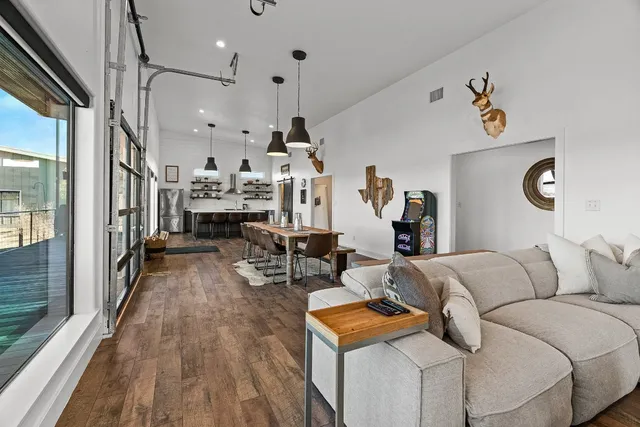 a kitchen with stainless steel appliances a dining table chairs and wooden floor
