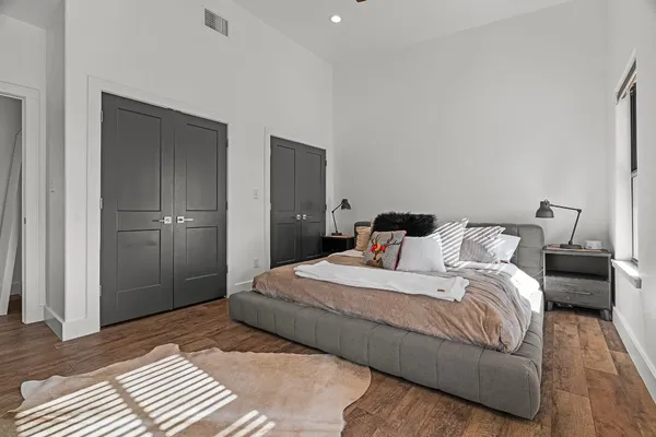 a bedroom with a bed and wooden floor