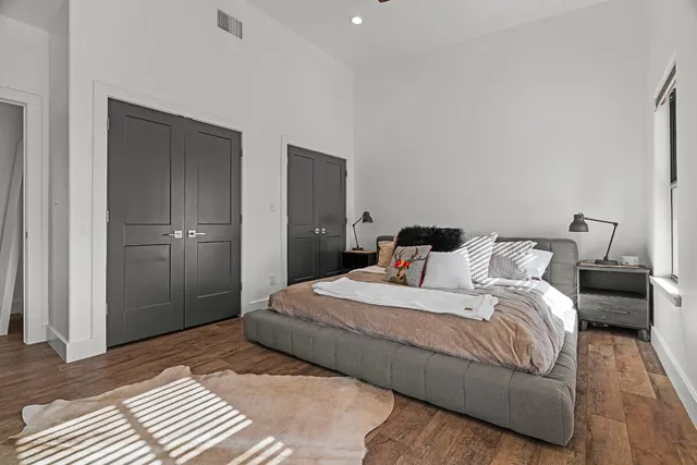 a bedroom with a bed and wooden floor