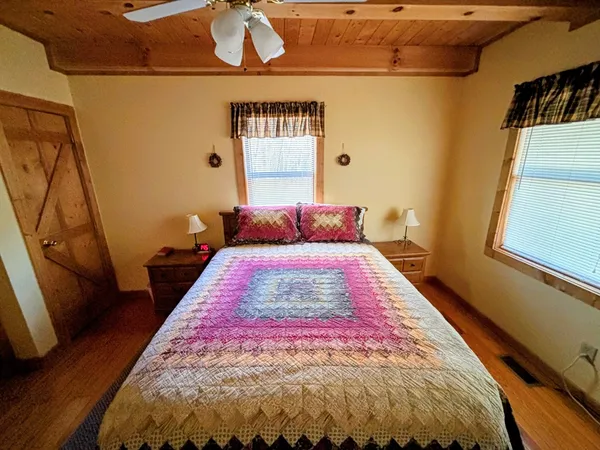 a bedroom with a bed and wooden floor